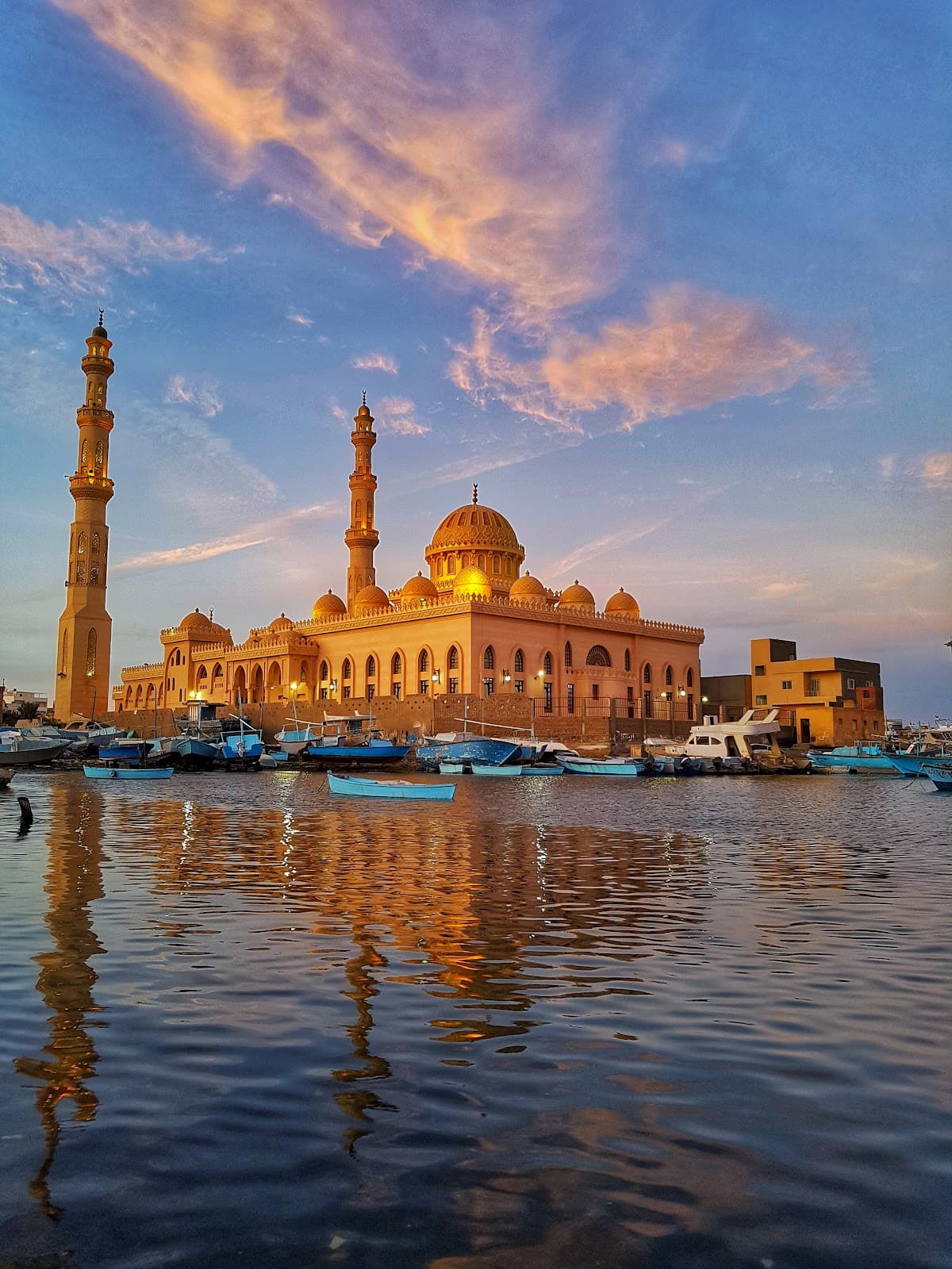 Iconic sunset view of Al Mina Mosque reflected in the water.