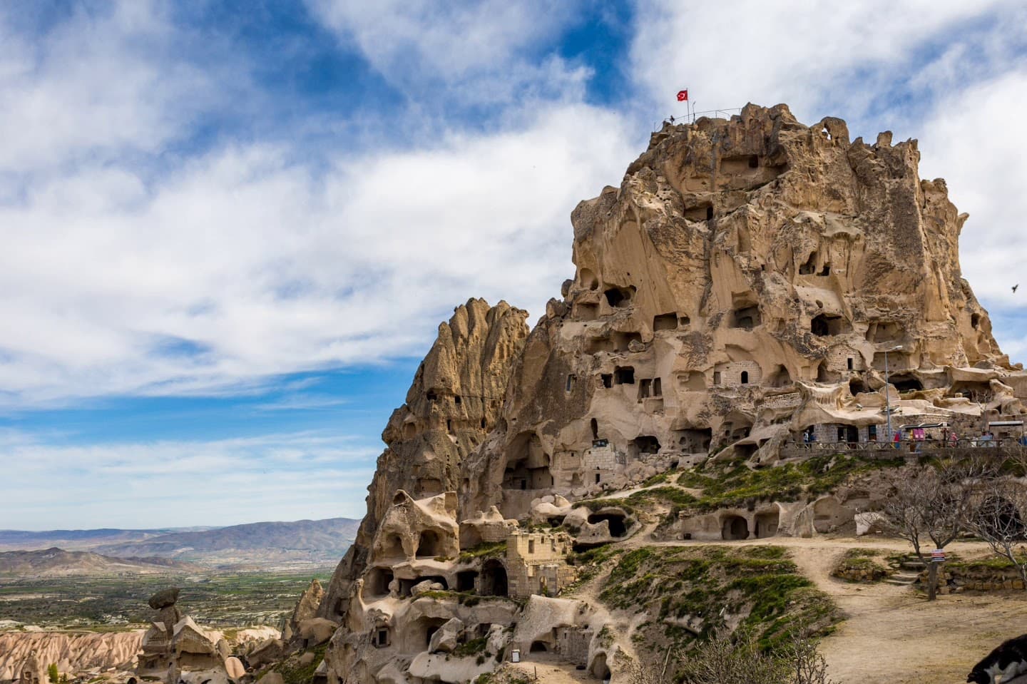 The iconic Uchisar Castle standing tall against a cloudy sky.