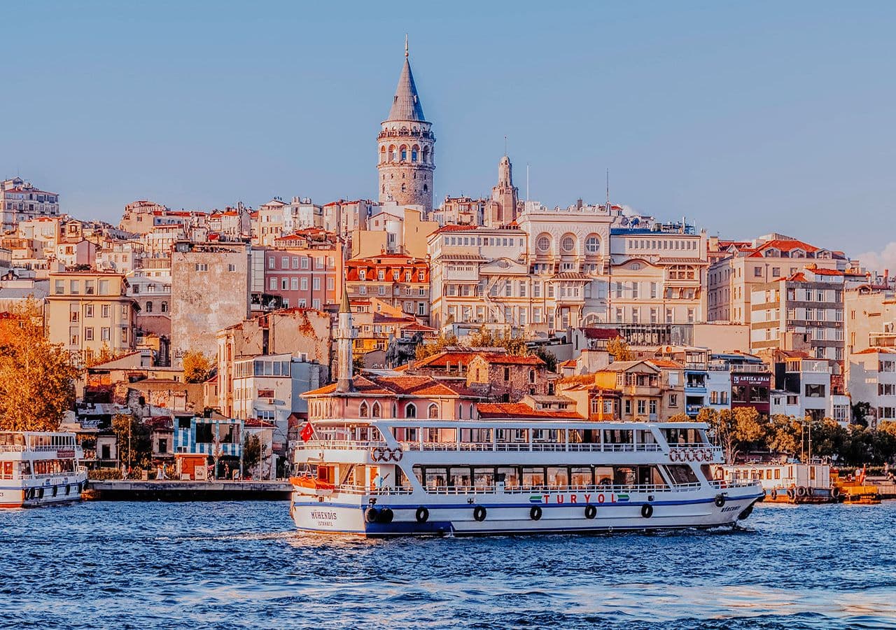 Iconic Istanbul skyline with Galata Tower and cruise boat.