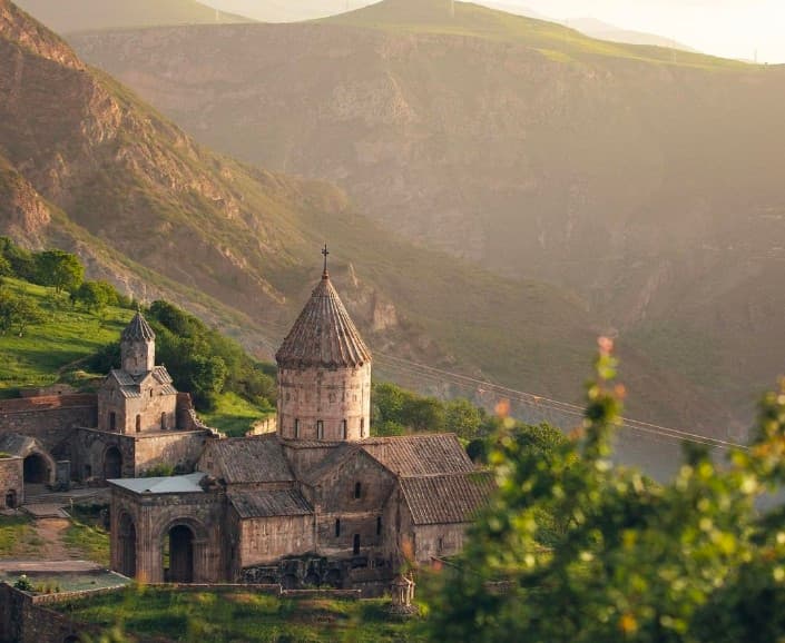 Iconic view of Tatev Monastery and the Vorotan Canyon at sunset.