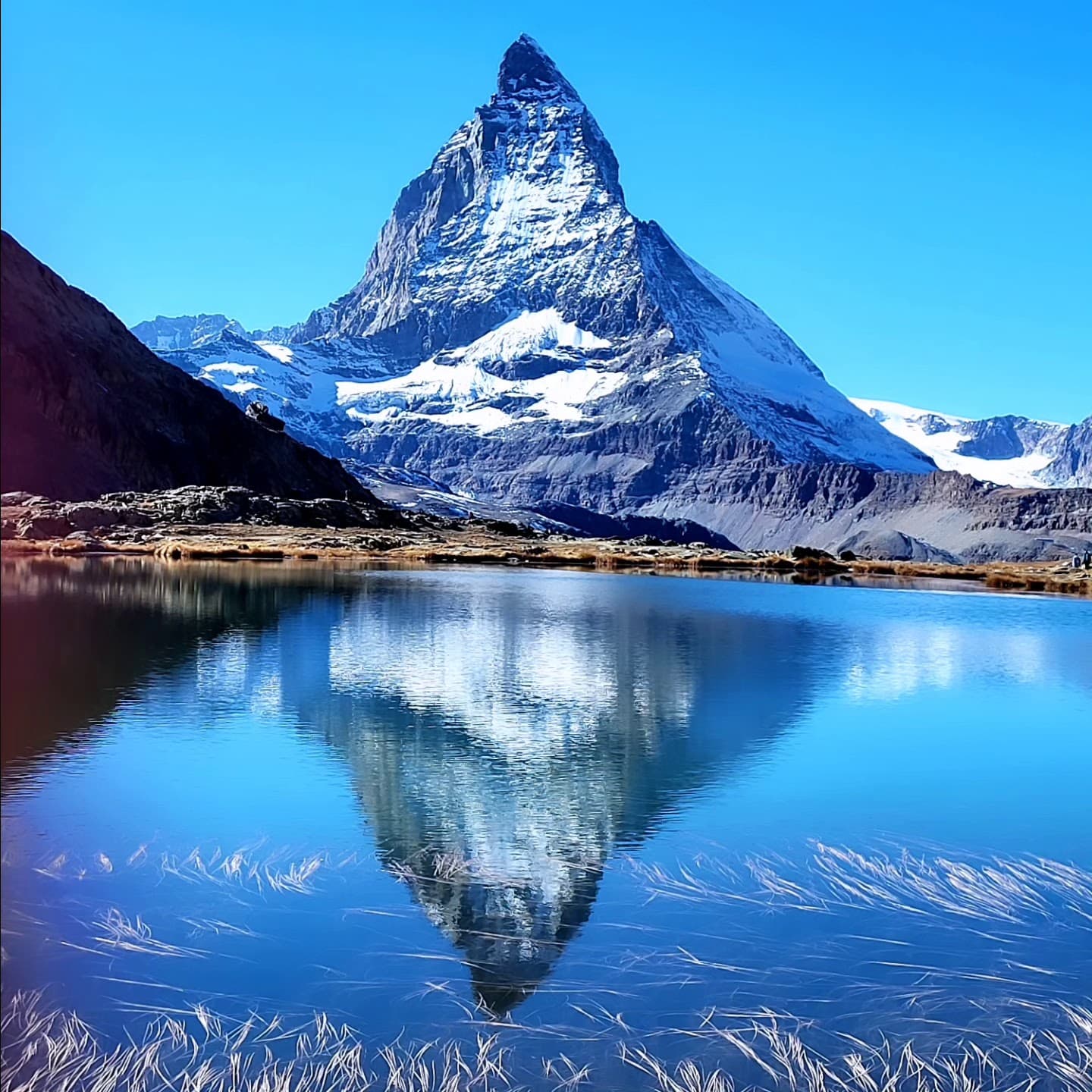 Iconic Matterhorn peak reflected in a serene alpine lake.
