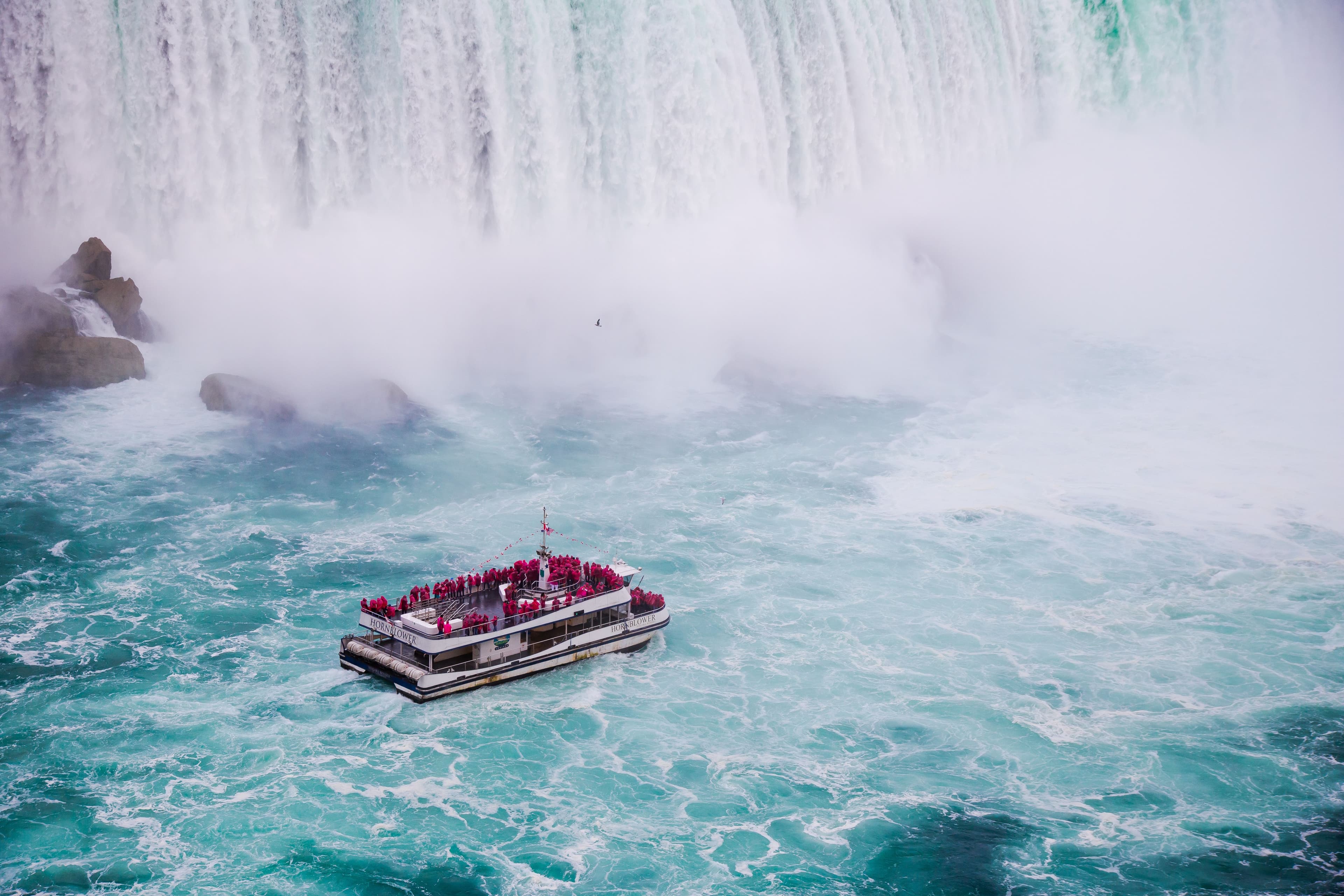Iconic red boat navigating the Horseshoe Falls mist.
