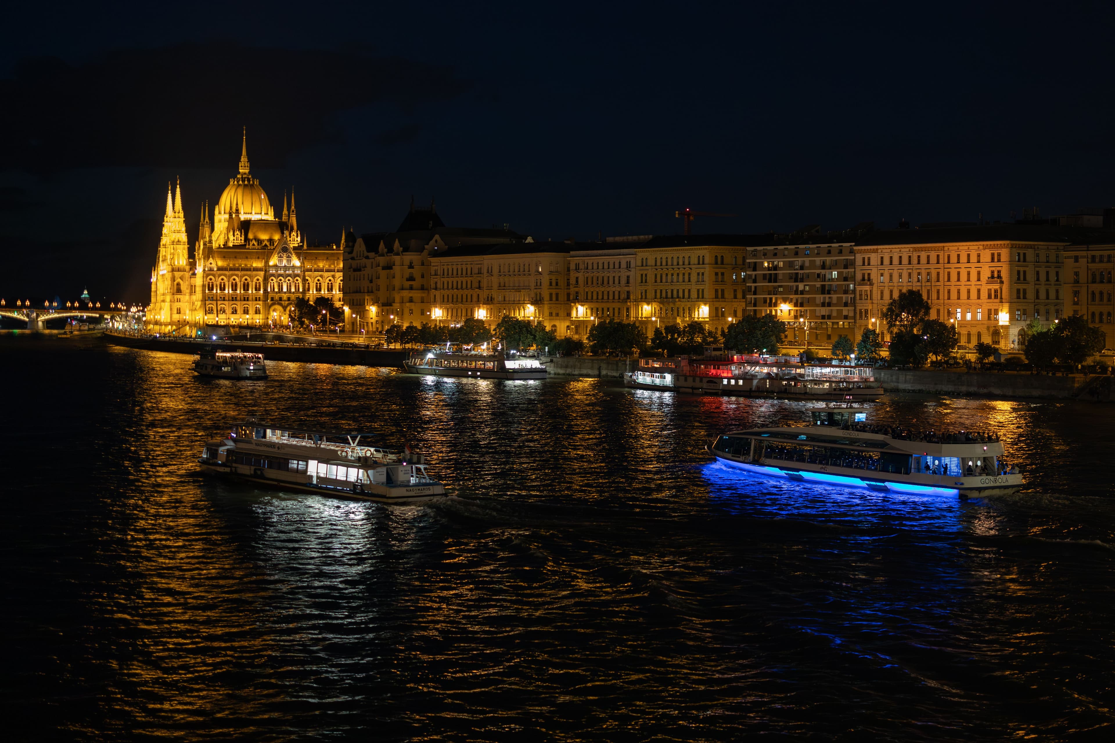 Stunning night view of the illuminated Parliament and boats.