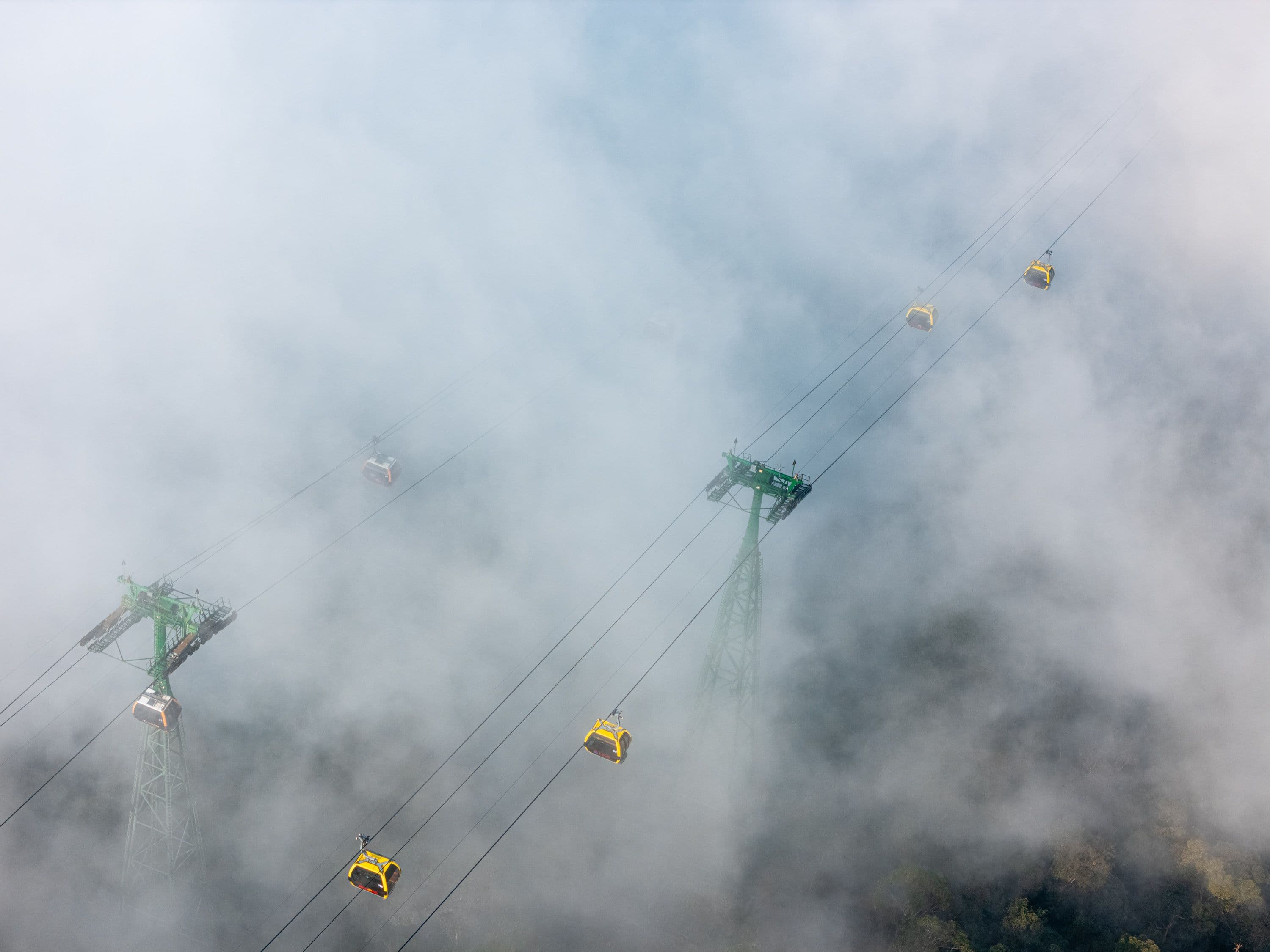 Stunning artistic shot of gondolas in the mountain mist.