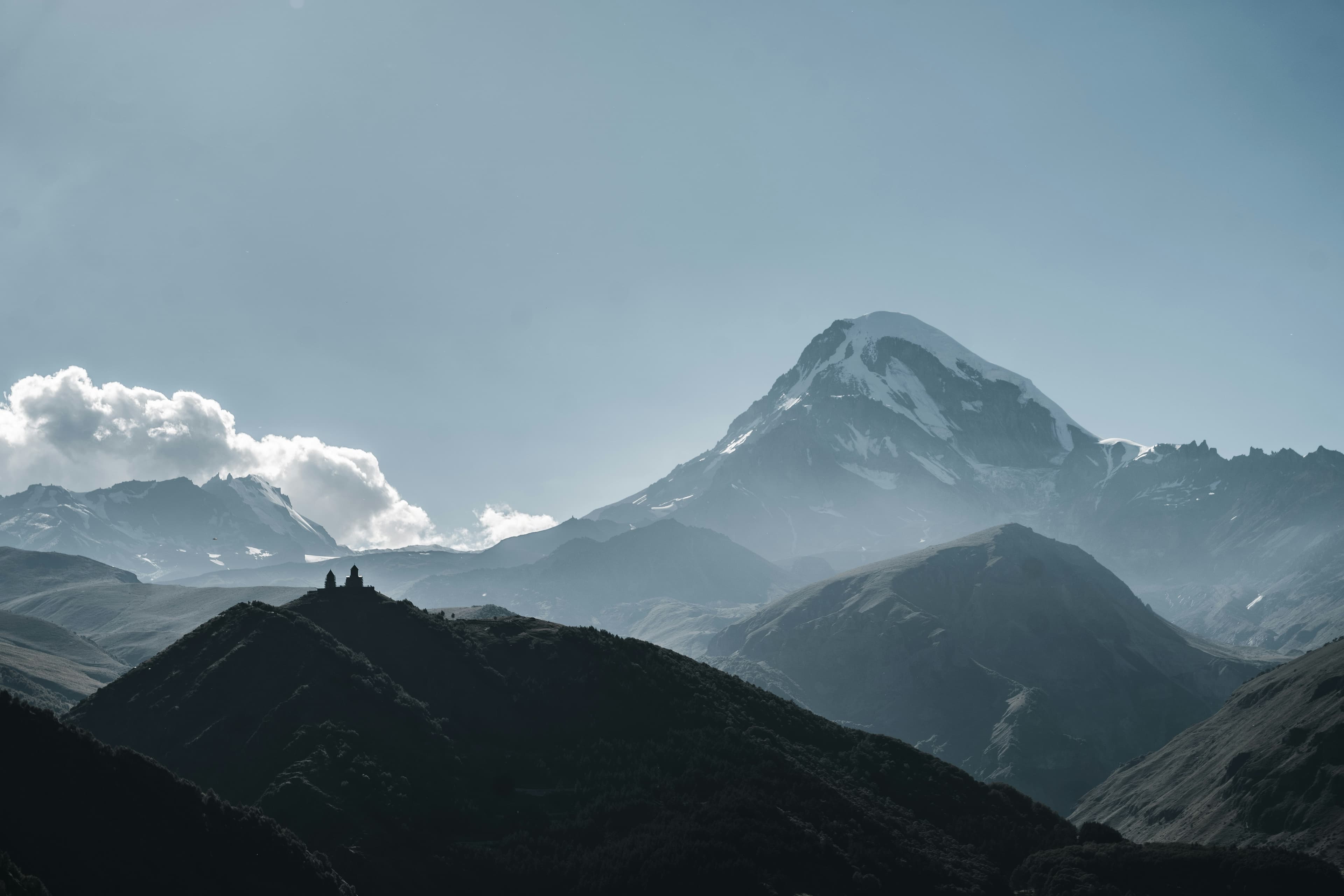 Iconic view of Gergeti Trinity Church with Mount Kazbek in the distance.