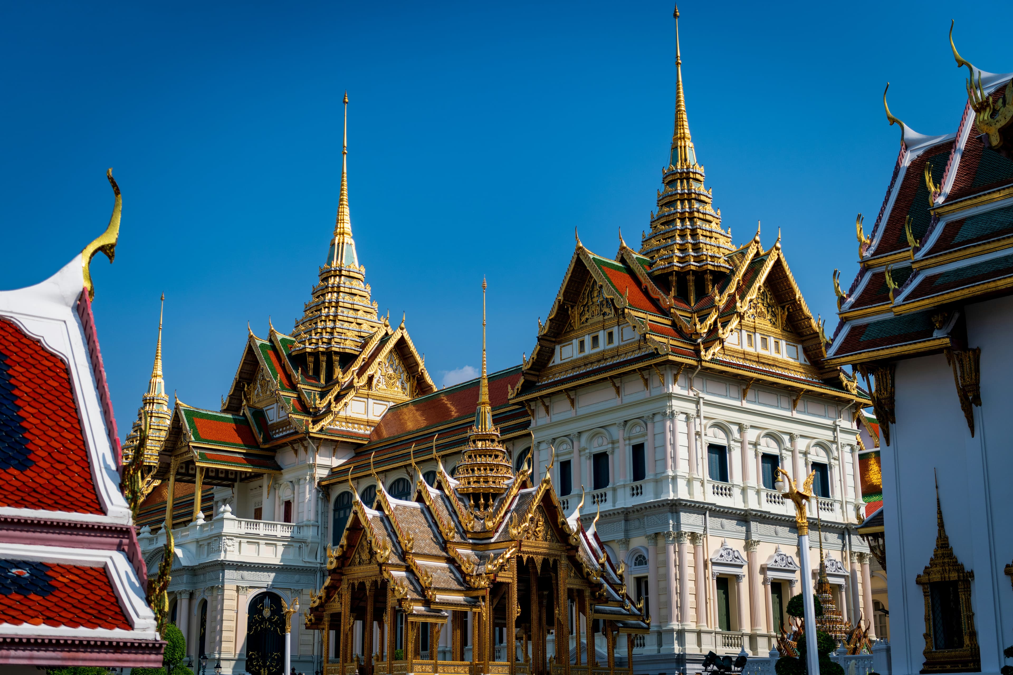 Ornate spires of the Grand Palace under a clear blue sky.