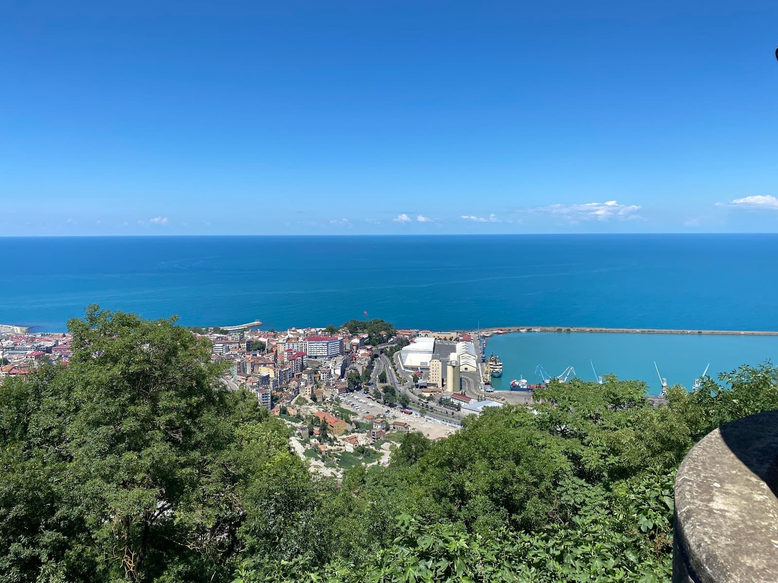 A breathtaking panoramic view of the Trabzon coastline and harbor from Boztepe Hill under a clear blue sky.