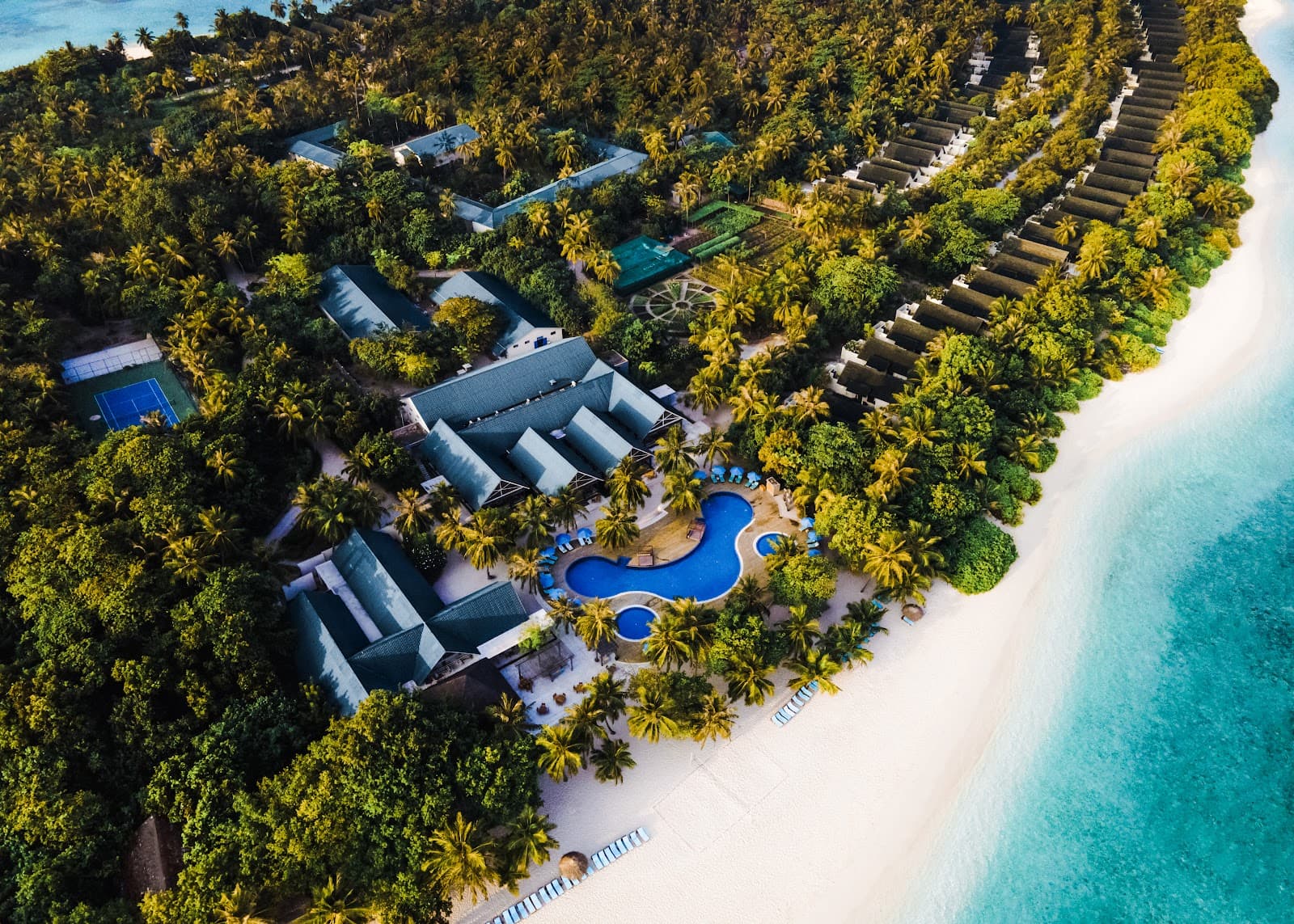 An aerial view of the lush Furaveri Island Resort & Spa in the Maldives, featuring white sandy beaches and a turquoise lagoon.