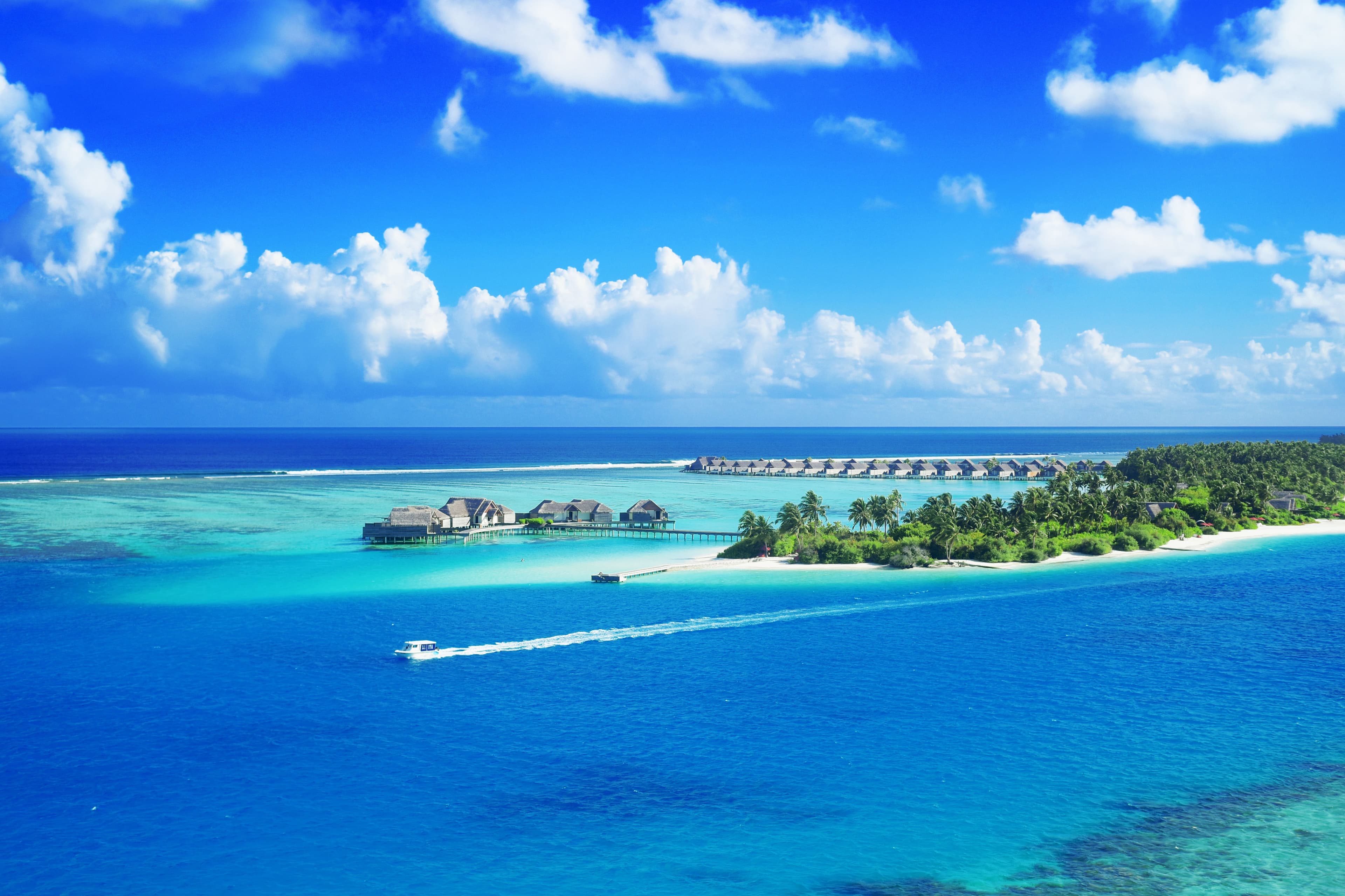 Aerial view of Maldives resort with turquoise lagoons.