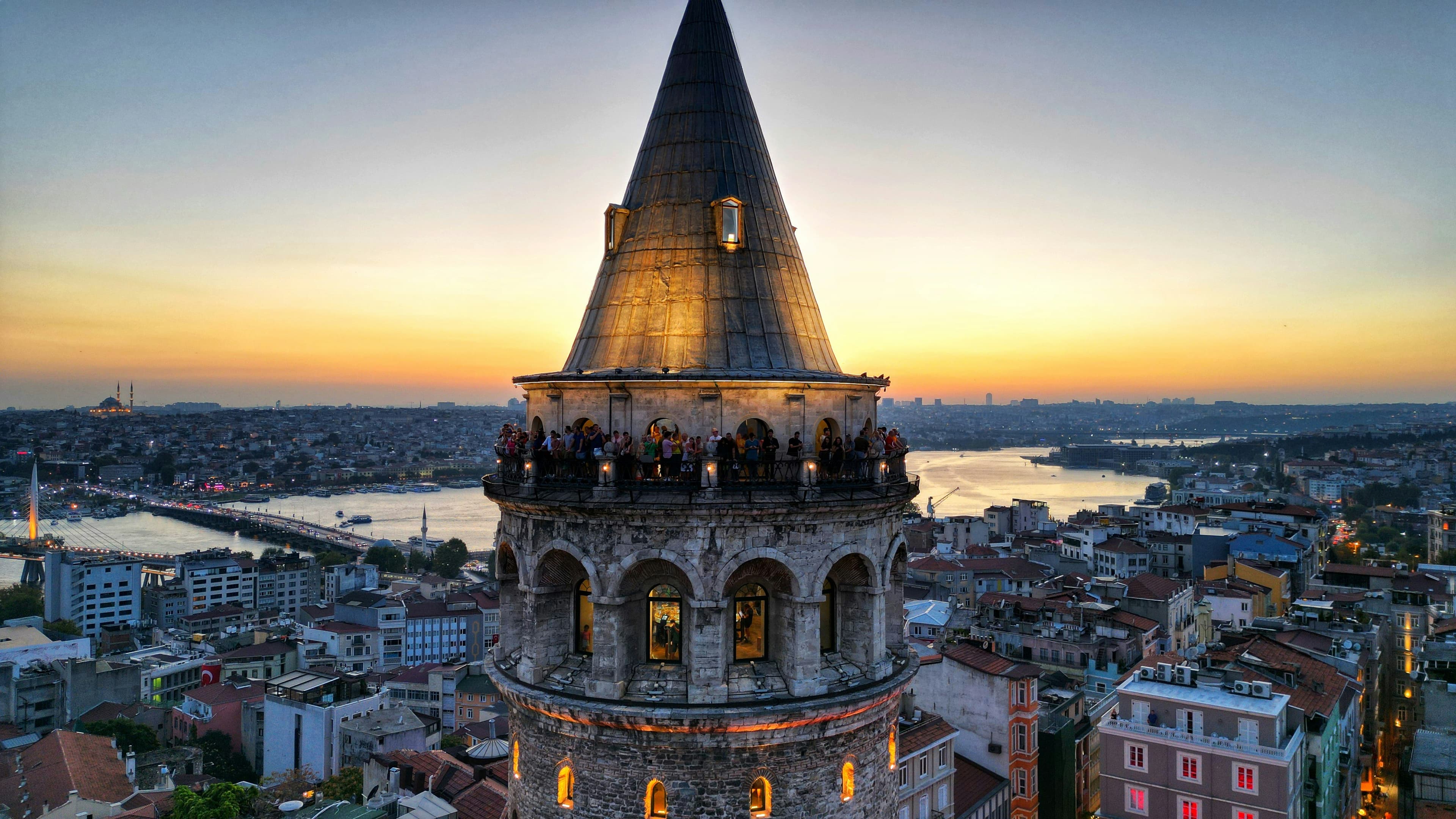 Galata Tower spire and observation deck at sunset overlooking Istanbul.